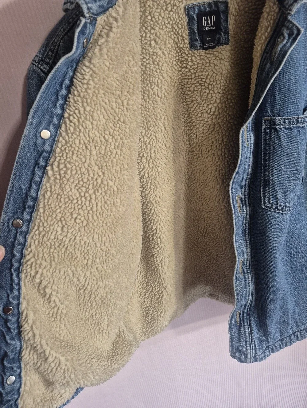 Gap denim jacket featuring a cozy tan sherpa lining and dual front patch pockets
